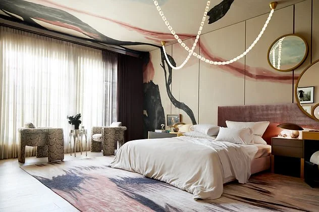 Modern bedroom with abstract wall art, bed, and decorative lighting